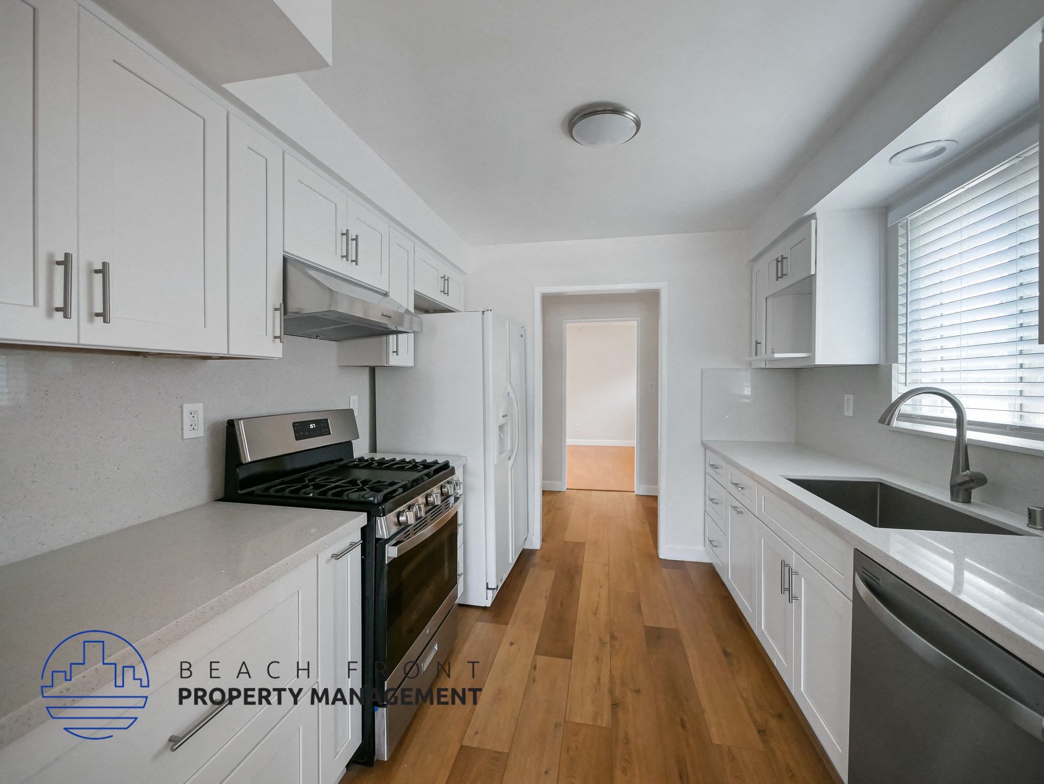 A kitchen with white cabinets and a stove top oven.